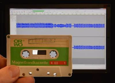 Das Foto zeigt eine Magnettonbandkassette mit einem Software-Fenster im Hintergrund.