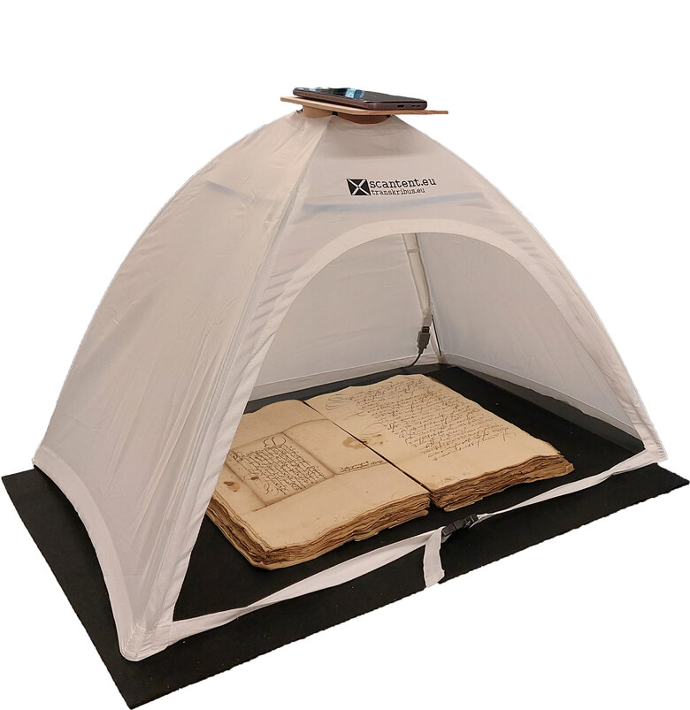 Das Foto zeigt Scanzelt, auf dem ein Smartphone liegt. Im Inneren des Zeltes liegt eine aufgeschlagene historische Akte.